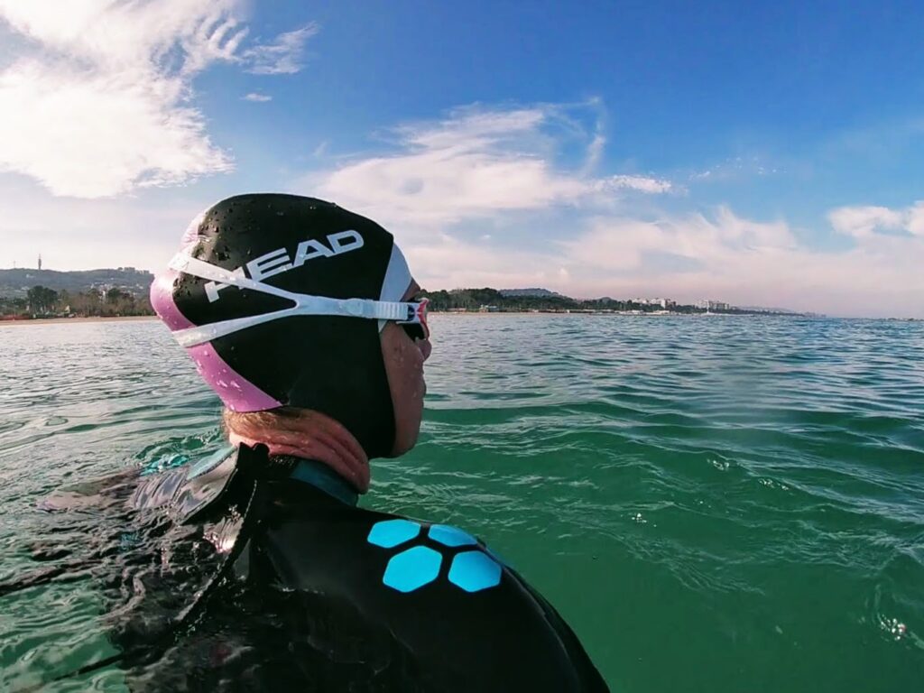 Woman wearing a neoprene swim hood and a wetsuit for open water swimming
